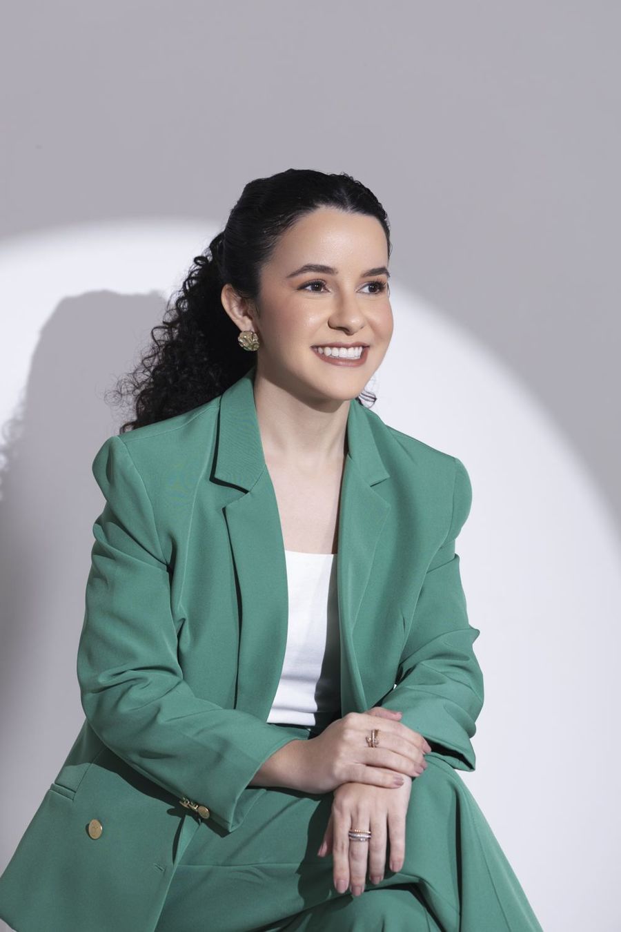 Dra. Larissa Quariguasi sorrindo, sentada